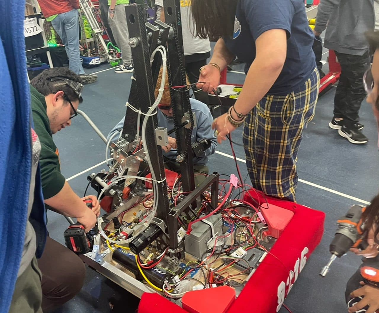 D.A.R.T. team mid-repair on the #9216 robot — Charged Up season