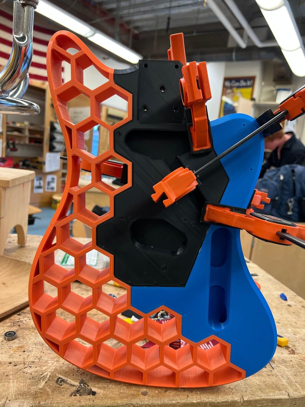 3D-printed guitar body, honeycomb infill, clamped up in the shop