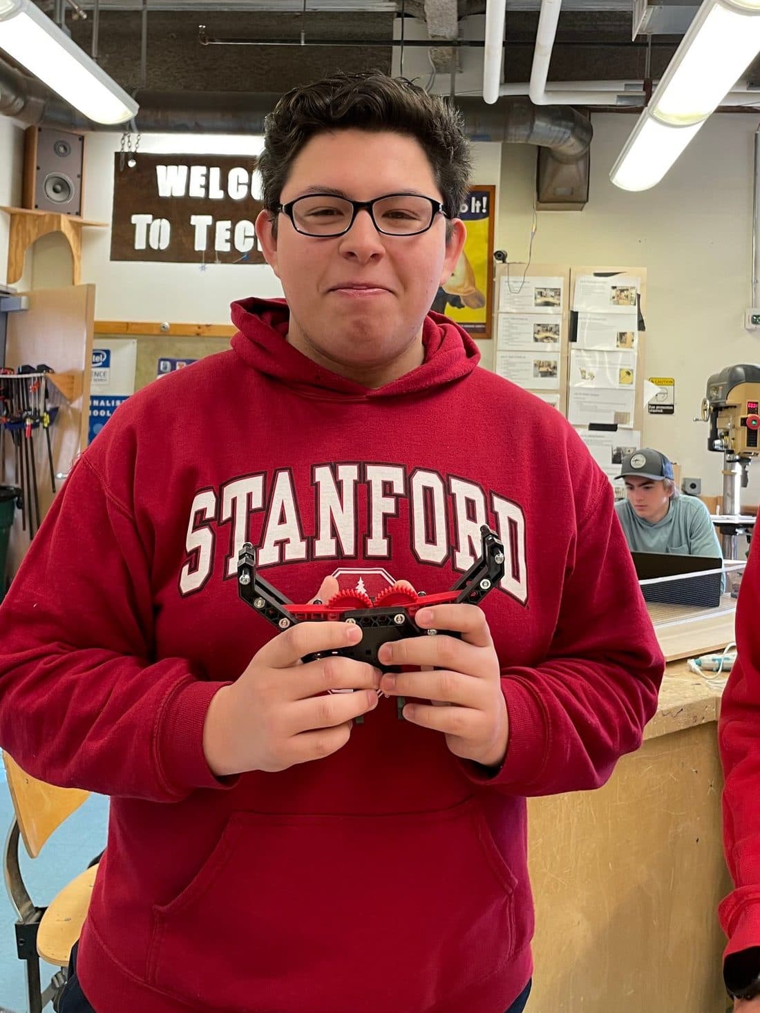 Josué in the shop, holding a gear assembly